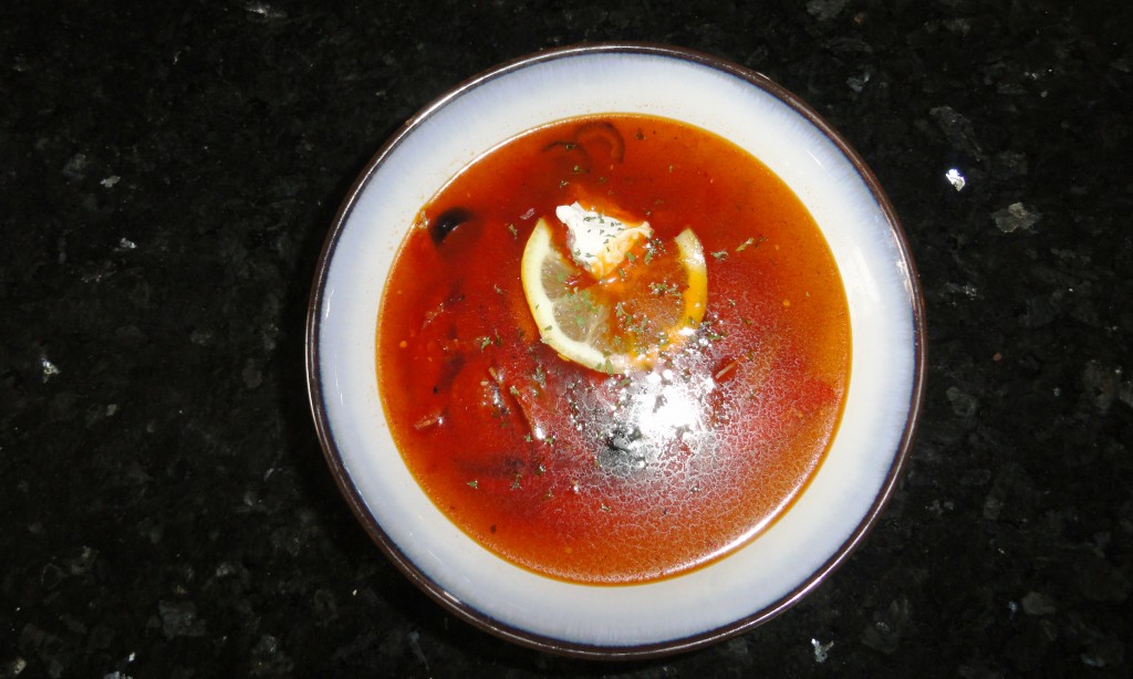 Solyanka with fresh lemon and sour cream.