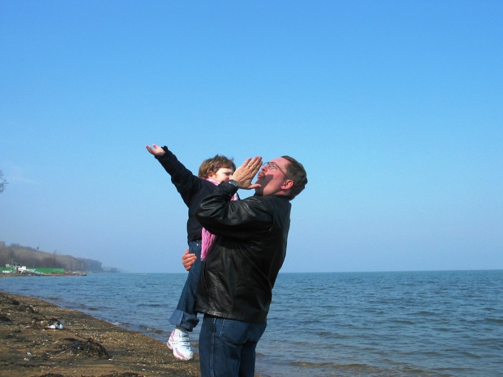 Sarah and Papa on the beach blowing kisses to the sun